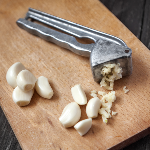Peeled garlic cloves from Sharbatly in a 1 kg vegetable pack, showing fresh, whole garlic with smooth, white surfaces.