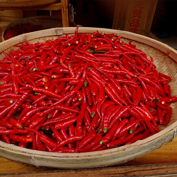 Fresh red baby Thai chilies in a 0.1 kg pack from Thailand, vibrant chili vegetables perfect for cooking.