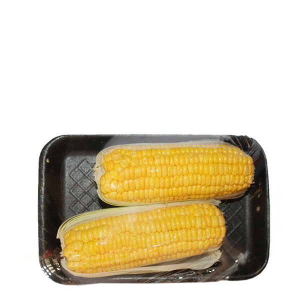 Two fresh corn on the cob pieces from Holland, vibrant yellow vegetable with green husks and kernels visible.