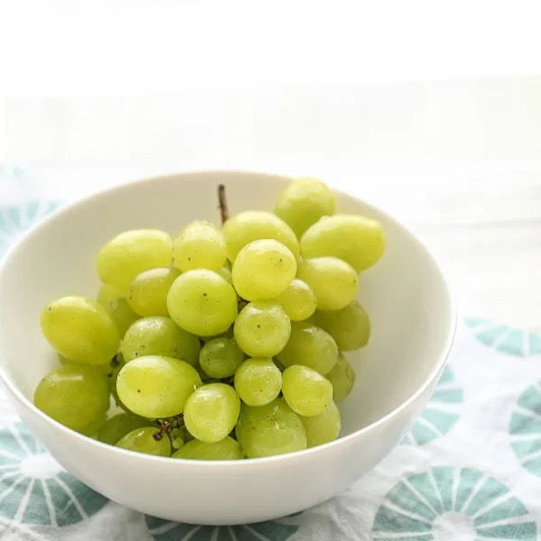 White seedless Cotton Candy grapes in a 1 kg punnet, displayed as fresh, vibrant grapes with a flower-shaped presentation.